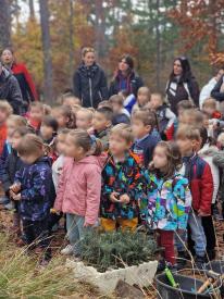 les enfants observent la femme qui leur explique le procédé 